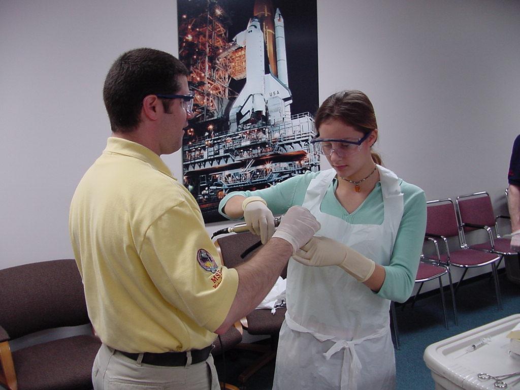 Paul Dixon helps student with heat sealing a flight sample tube