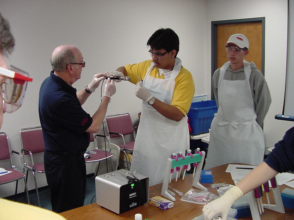 Jim Porter helps student with heat sealing a flight sample tube