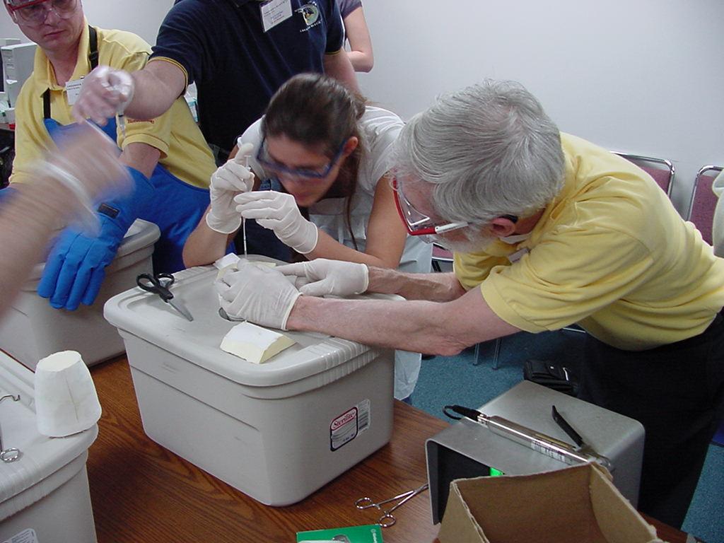 Merle Myers helps a student check for bubbles in a flight sample